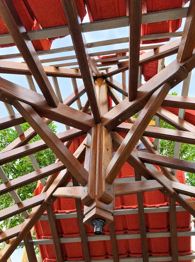 Rangka atap kayu pendopo dilihat dari bawah, balok-balok memusat ke tiang tengah