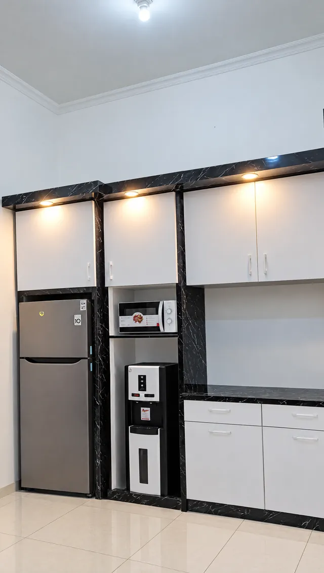 Kitchen set kabinet putih dengan rangka motif marmer hitam, tempat kulkas dan dispenser