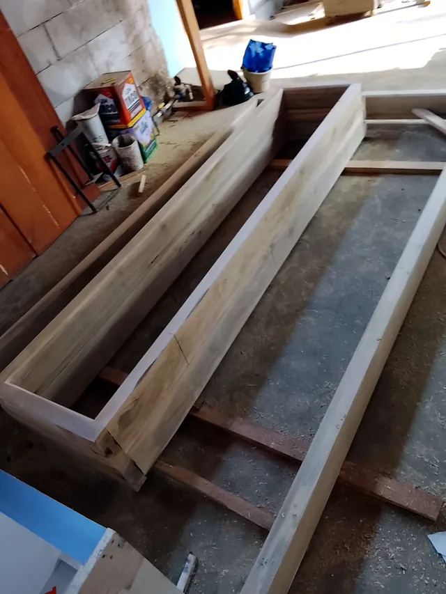Rangka kusen kayu yang sedang dirakit di lantai workshop